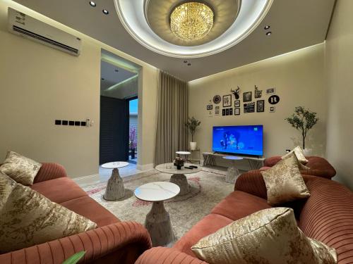 a living room with two couches and a tv at شقة غرفة وصالة وجلسة خارجية بالعارض ٨ in Riyadh