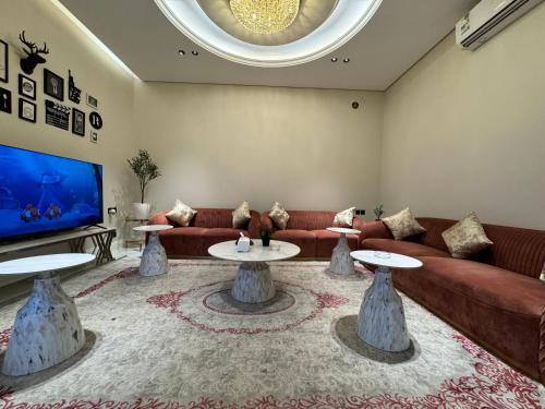 a living room with a couch and two tables at شقة غرفة وصالة وجلسة خارجية بالعارض ٨ in Riyadh