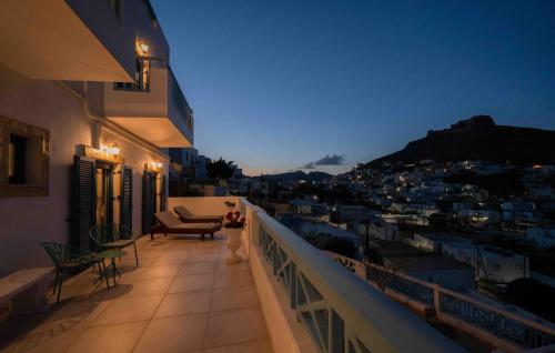 a woman standing on a balcony looking at the city at HELIADES SUITES in Panteli