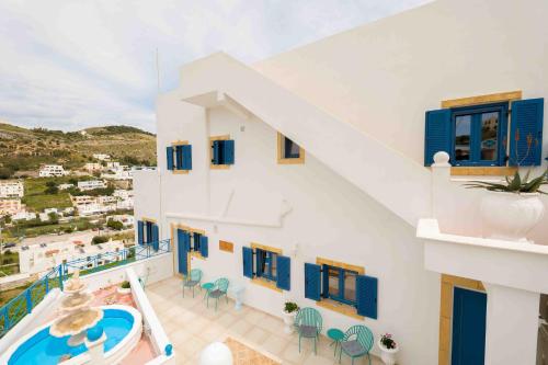 una vista de una casa con ventanas azules y una piscina en HELIADES SUITES, en Panteli