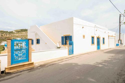 a white building with blue doors on a street at HELIADES SUITES in Panteli