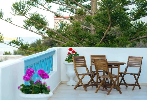 a table and chairs on a balcony with flowers at HELIADES SUITES in Panteli