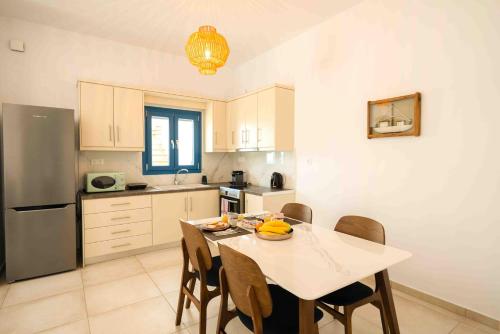 a kitchen with a table with chairs and a refrigerator at HELIADES SUITES in Panteli