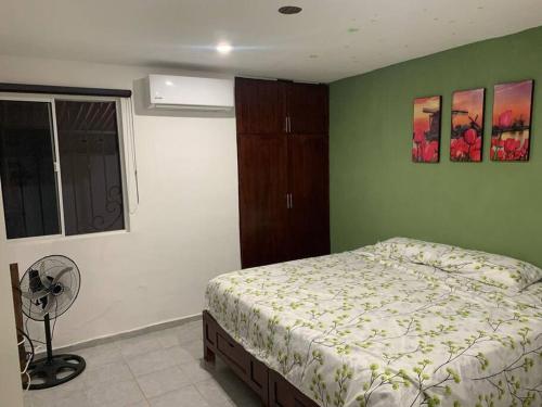 een slaapkamer met een bed en een ventilator bij Residencia con gran espacio, cómoda y fresca. in Mérida