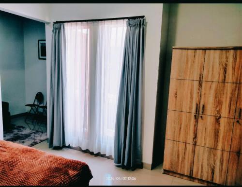 a bedroom with a bed and a window at WiHouse Bali in Denpasar
