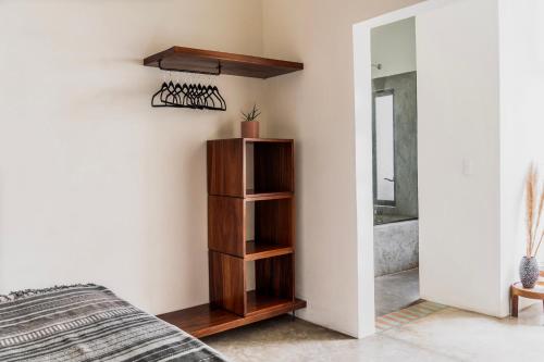 a bedroom with a wooden book shelf next to a bed at Residencia Tropical Don Bonito in Sayulita