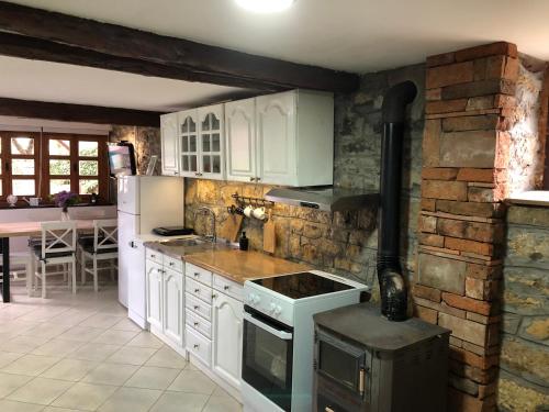 a kitchen with white appliances and a brick wall at Kuća Mitića in Pirot