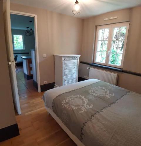 une chambre avec un lit, une commode et un bureau dans l'établissement Gîte vallée du denacre entre terre et mer, à Wimille