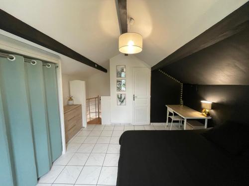 une chambre avec un lit et un bureau dans une pièce dans l'établissement Charmante maison mitoyenne, à Melun