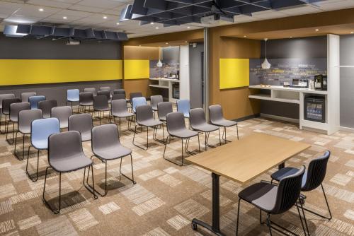 a waiting room with chairs and tables in a cafeteria at ibis Lille Centre Gares in Lille