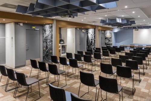a room with rows of chairs in a waiting room at ibis Lille Centre Gares in Lille