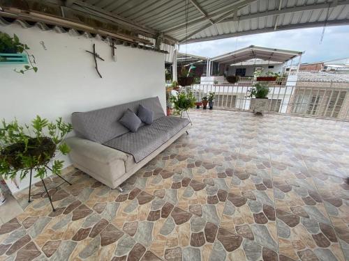 a couch sitting on a patio with a stone floor at Hermoso apartamento con terraza in Cali