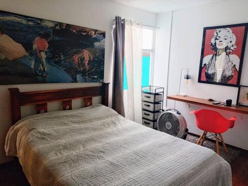 a bedroom with a bed and a painting on the wall at Amplio apartamento con terraza in San Pedro