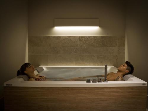 a man and woman sitting in a bath tub at A.Roma Lifestyle Hotel in Rome