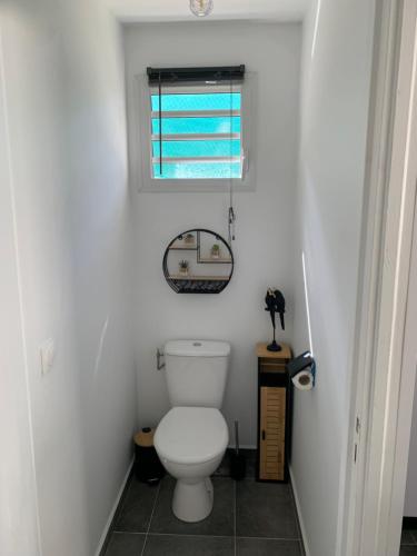 La salle de bains est pourvue de toilettes et d'une fenêtre. dans l'établissement Maison T2 situé à Sainte Anne, à Sainte-Anne