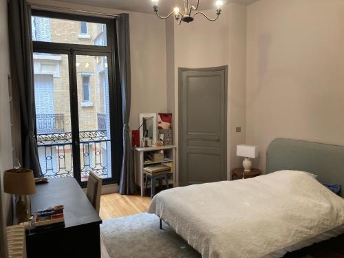 une chambre avec un lit et une fenêtre dans l'établissement Appartement de standing, à Paris