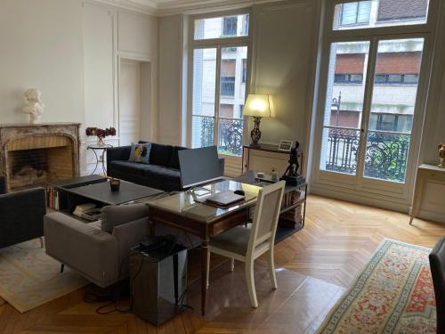 un salon avec une table avec un ordinateur portable dessus dans l'établissement Appartement de standing, à Paris