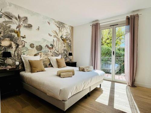 une chambre avec un grand lit avec un tableau au mur dans l'établissement Bastide de charme sous les pins avec piscine, à Saint-Paul-de-Vence