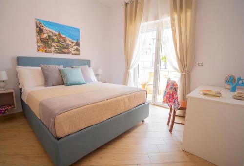 een slaapkamer met een bed en een groot raam bij SYMPHONY HOUSE in Sorrento