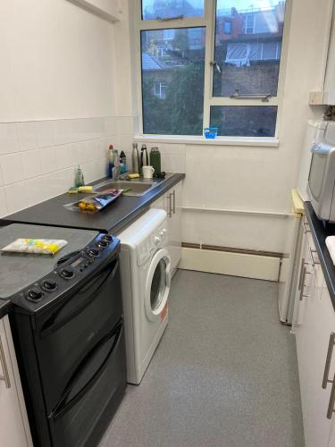 a kitchen with a washer and dryer in it at Bridgestone in London