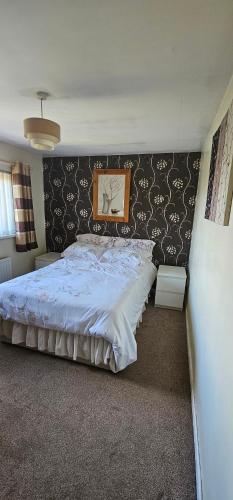 una camera con un grande letto con testiera in bianco e nero di Room to rent a Belfast
