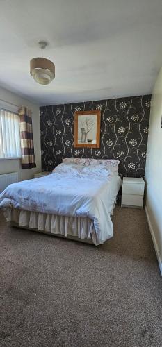 una camera da letto con un grande letto e un piumone blu di Room to rent a Belfast