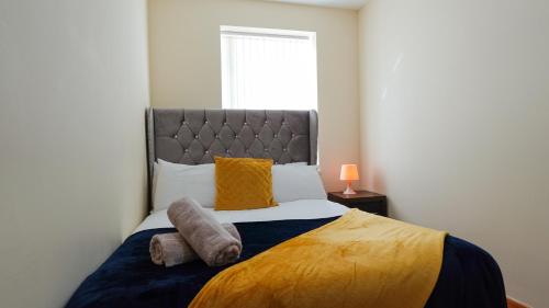 - une chambre avec un grand lit et des oreillers jaunes dans l'établissement The StayLuxe Apartment Manchester, à Manchester