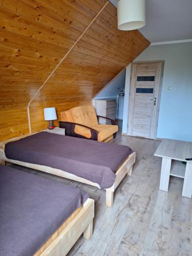a bedroom with two beds and a couch at Borowy Zakątek in Stara Kiszewa