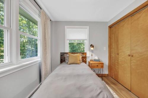 um quarto com uma cama e uma janela em Cozy cottage in the woods em Surry