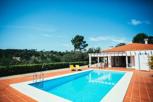 a swimming pool in front of a house at Fátima-Ourém - Quinta da Luz - breakfast included in Ourém