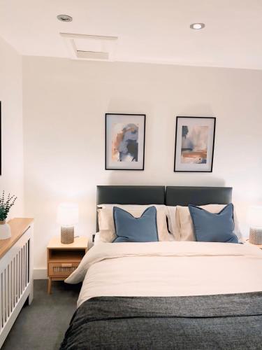1 dormitorio con 1 cama grande con almohadas azules en The Hideout en Gillingham