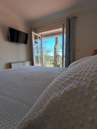 a bedroom with a bed and a large window at Fátima-Ourém - Quinta da Luz - breakfast included in Ourém