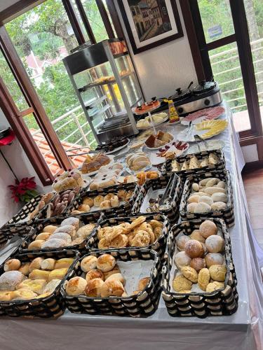 a buffet table filled with different types of pastries at Pousada Atalaia Capivari in Campos do Jordão
