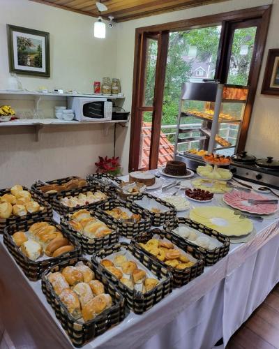 a buffet with many different types of food on a table at Pousada Atalaia Capivari in Campos do Jordão