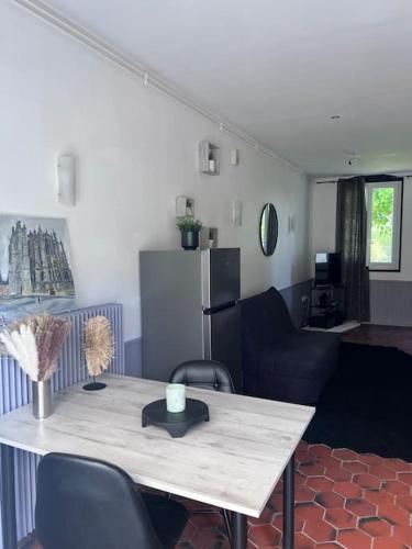 une chambre avec une table et des chaises ainsi qu'un salon dans l'établissement Studio aux abords des étangs, à Milly-sur-Thérain