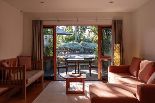 a living room with a couch and a table at Bow Street Apartments & Cottage in Raglan