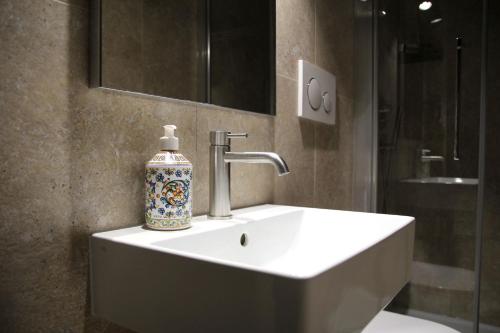 uma casa de banho com um lavatório e um vaso em Principe Guesthouse powered by Joyful Guesthouse em Roma
