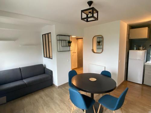 un salon avec un canapé, une table et des chaises dans l'établissement Studio vue mer Presqu'ile de Giens (Porquerolles - Var), à Hyères