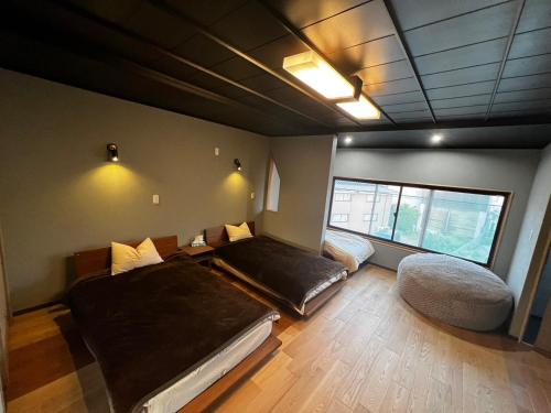 Habitación con 2 camas y ventana en 貸し切りゲストハウスsai2nd en Yasugi