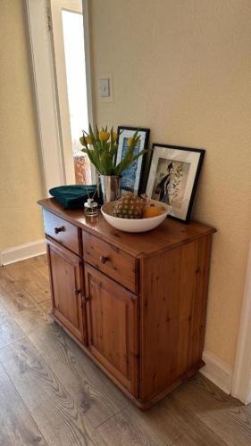um armário de madeira com uma taça de fruta em cima em The Peach Room em Edimburgo