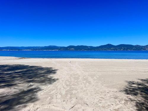 una spiaggia sabbiosa con vista sull'oceano di Chic Studio Climatisé avec Parking 5mn plage a Saint-Tropez