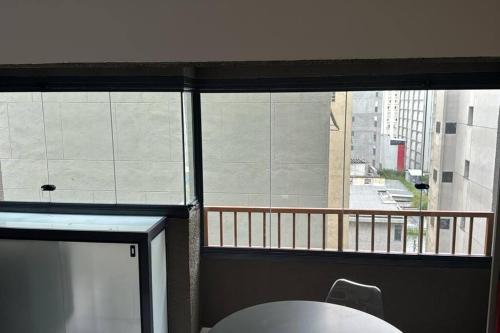 una finestra in una camera con tavolo e balcone di Studio aconchegante a 2 min da Av. Paulista - Estação Trianon-MASP a San Paolo
