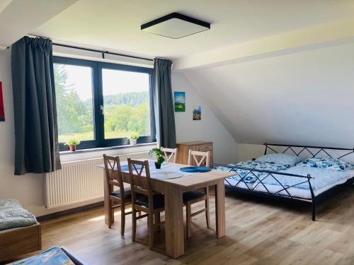 1 dormitorio con mesa de comedor y 1 cama en Apartmány Větrná 29, en Malšín