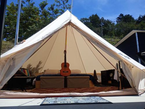 ein weißes Zelt mit einer Gitarre darin in der Unterkunft Better Life Mountain Camp Monte Verde in Monteverde Costa Rica