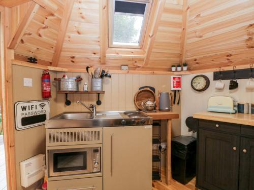 a kitchen with a sink in a tiny house at Woodmans Huts in Haverthwaite
