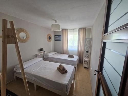 Una pequeña habitación con dos camas y una ventana. en Azahar, en Córdoba