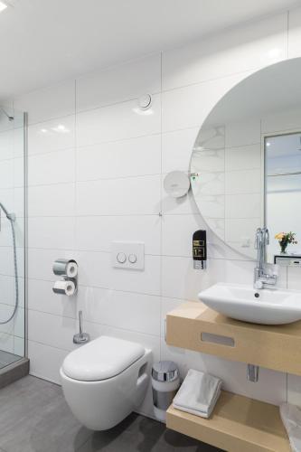a bathroom with a toilet and a sink and a mirror at Hotel Bayer's in Munich