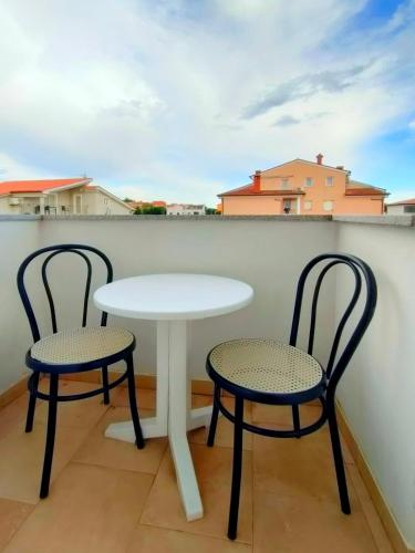 a white table and two chairs on a balcony at Apartments Zova in Medulin