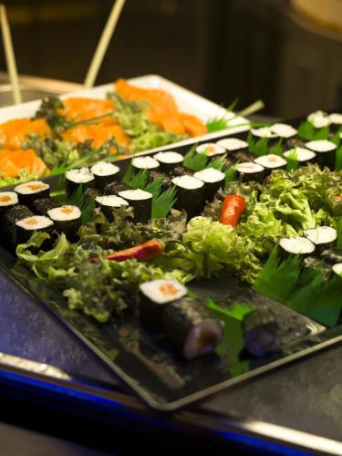 a tray of sushi and vegetables on a table at A.Roma Lifestyle Hotel in Rome