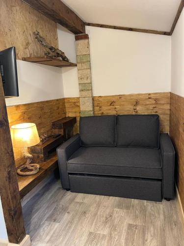 a living room with a couch and a tv at Two-Bedroom Cosy Country Lodge with Private Patio in Greenhithe